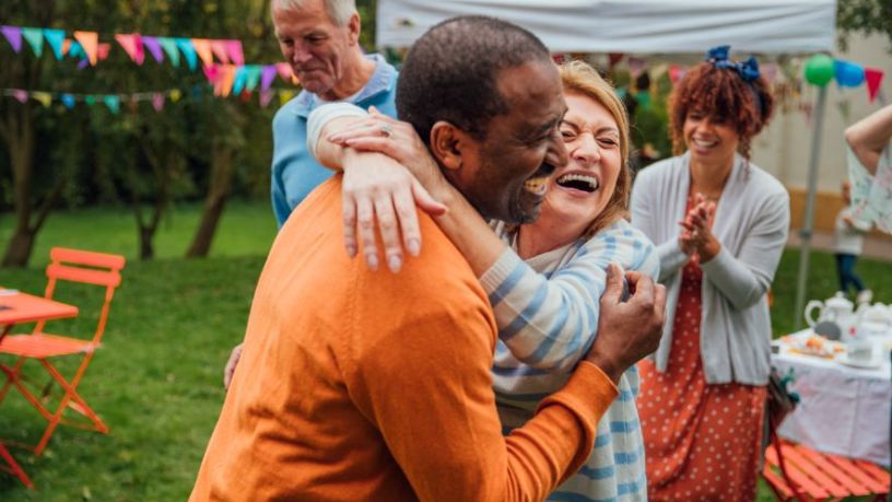 Man and woman hugging and laughing.