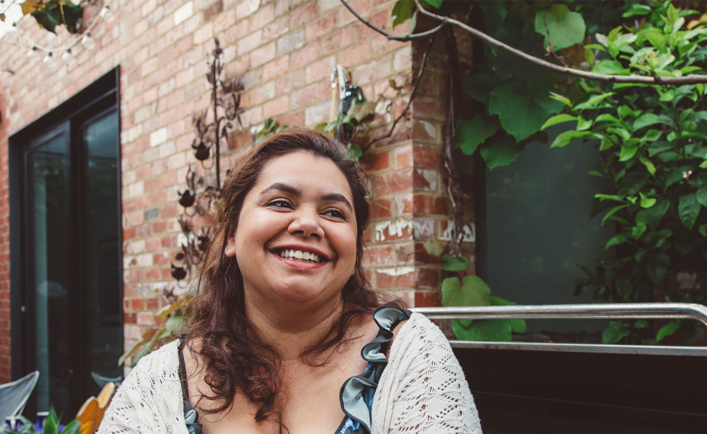 Smiling woman standing outside home