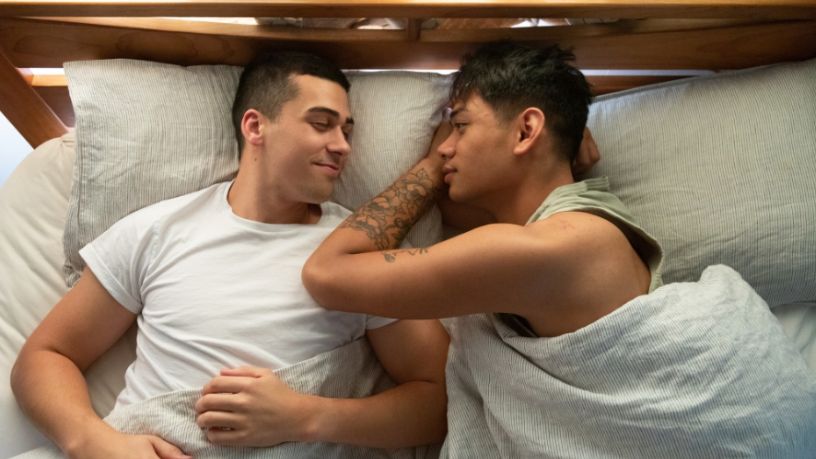 Two men lying in bed.