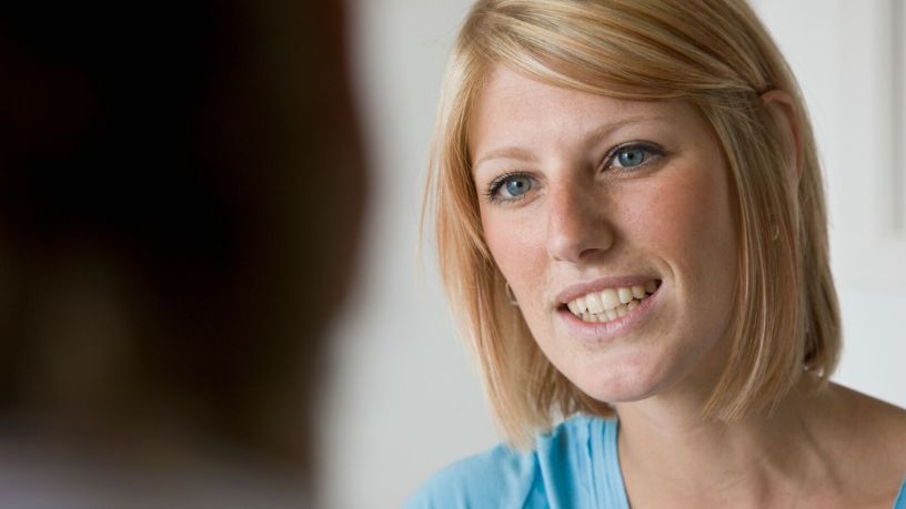 Woman therapist smiling at patient in front of her