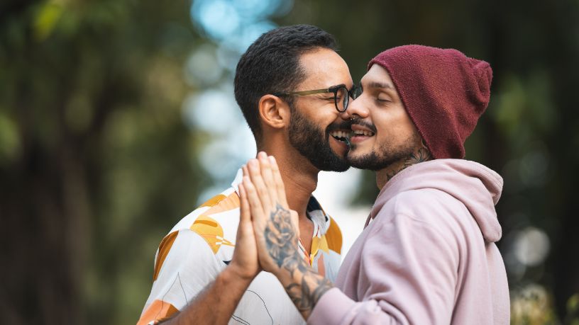 Two men dance together in the sunshine.