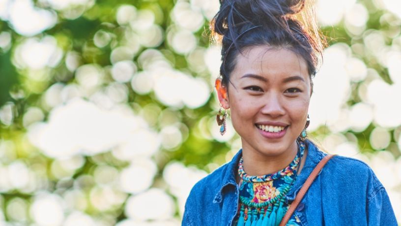 A woman wearing a blue top smiles at the camera.