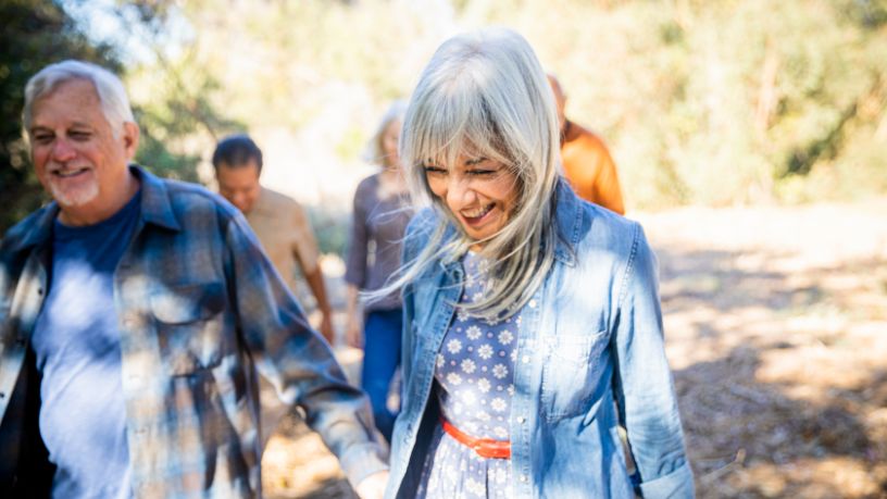 A woman and man hold hands as they walk with friends.
