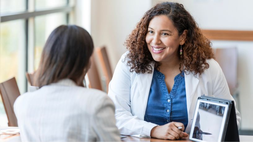 A doctor shows her patient results on a tablet.