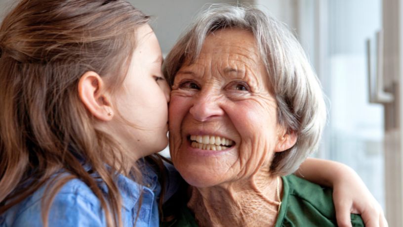 A woman looking out of frame smiles.