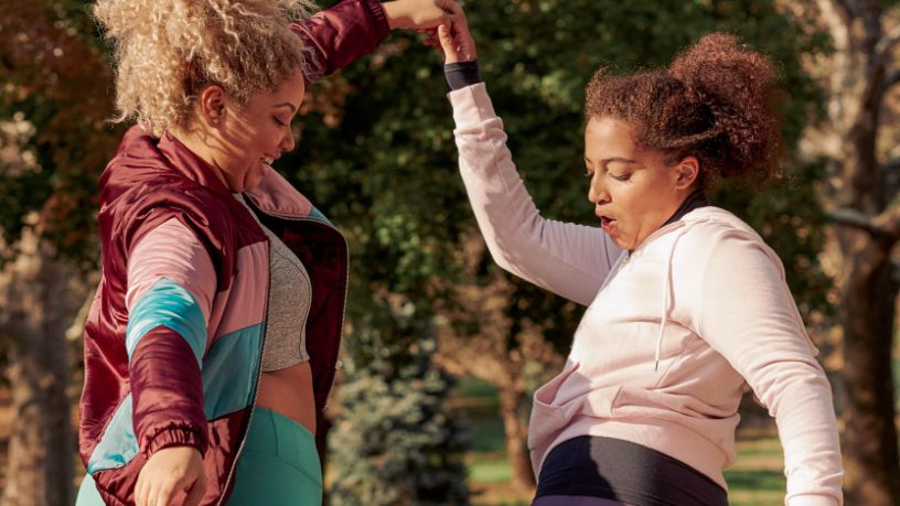 Two women dance outside.