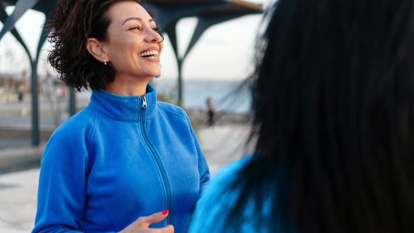A woman laughs with her friend.