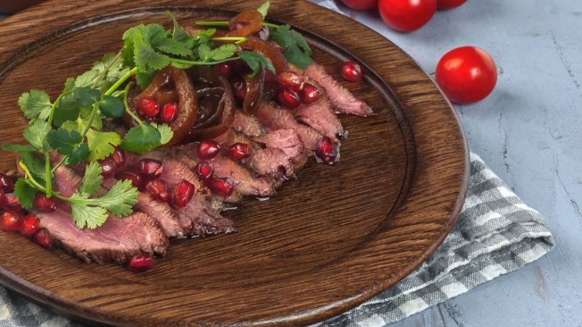 A platter of BBQ lamb lays on a table.