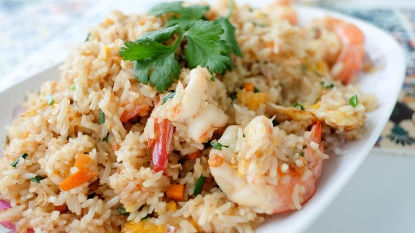A serving dish is filled with stir-fried garlic prawns and cauliflower rice.