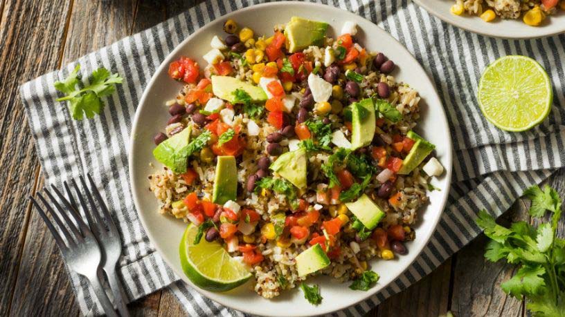 A plate of chargrilled Mexican vegetable and quinoa salad sits on a dining table