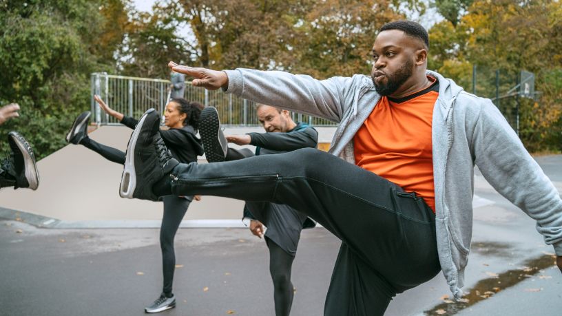 A man swings his foot to his hand as he stretches.