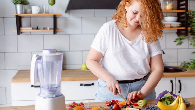 A man sits with his dog on his lap while looking at his phone.