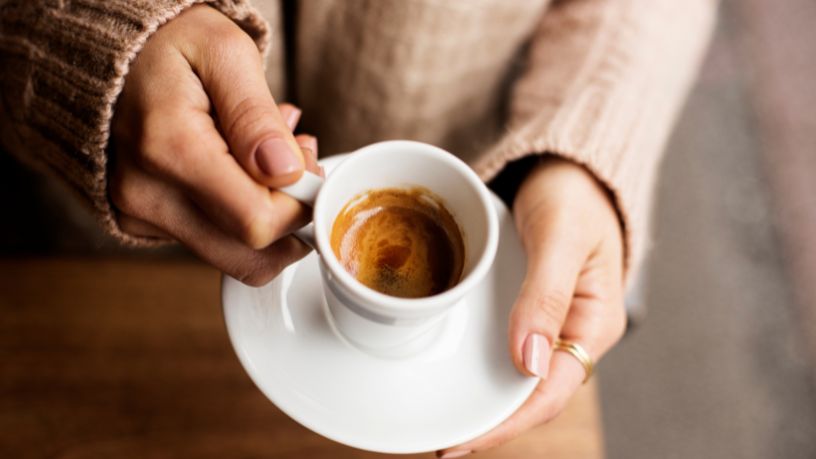 A person holding a cup of coffee.