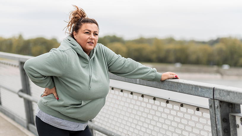 A woman resting while out exercising.